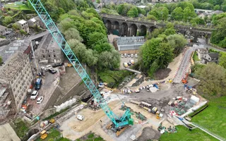 Drone shot of a blue crane and building site below