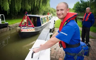 Man opening lock gate to let boat through