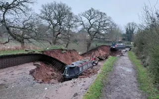Sink hole on a canal with narrowboats in the middle.