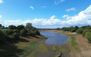 Low water levels in a reservoir surrounded by trees