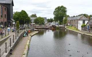 A canal basin with one boat moored at the far end, lined by residential buildings