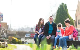 Family sits on a lock gate