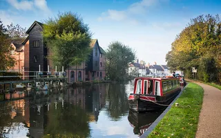 Narrowboat moored on the towpath opposite houses on the Kennet & Avon Canal