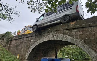 Van on the edge of a bridge