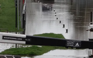 Canal water floods over the towpath and lock