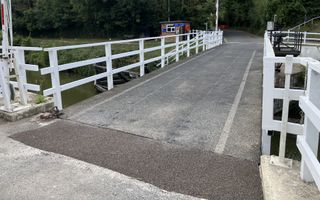 A newly laid tarmac road across a swing bridge over the canal.