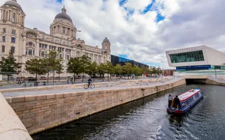 a canal with a boat and large gand building in the background
