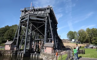 A large black steel structure straddles the canal, for lifting boats from one level to another.