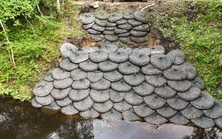 Ariel shot of rock bags piled ontop of each other next to a river