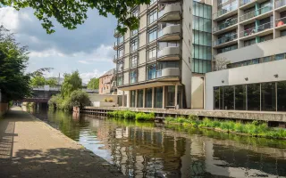 wide shot of a canal next to a building on a cloudy day