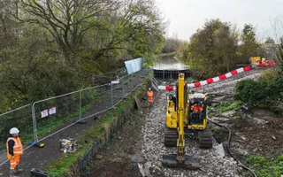 Ariel shot of a canal and repair workers with digger