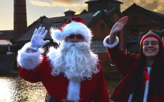 Santa and an elf waving to camera