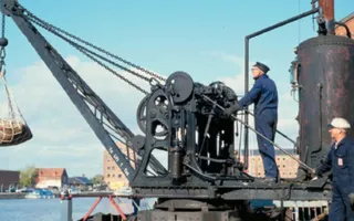 Old photo of worker using a canal crane