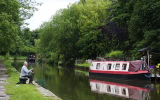 Angler on Macclesfield Canal with boat moored opposite