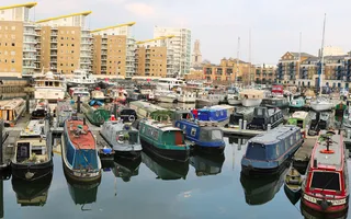 Lots of boats moored at Limehouse Basin, surrounded by high-rise buildings