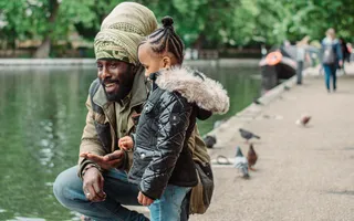 A man and child feeding ducks