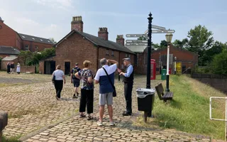 Wide shot of a court yard with brick road and people standing on top