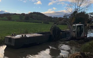 Digger and boat on a canal