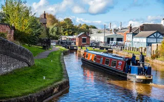 A canal boat heading towards a lock