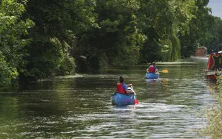 A person canoeing on a quiet canal