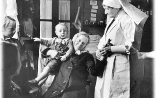 Old black and white photo of a a nurse a woman and children