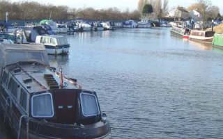 Boats moored on both sides of a wide stretch of the Fossdyke Canal