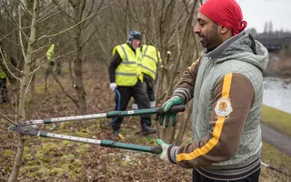 Volunteer cuts branches with shears at Smethwick in Birmingham