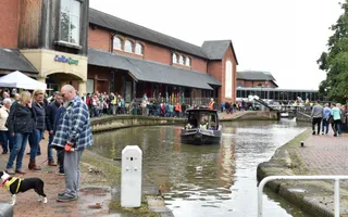 Narrowboat passes crowds on the towpath