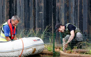 Volunteers in high vis and life jackets build floating reedbeds