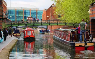 Two narrowboats pass each other on the canal in central Birmingham
