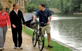 A cyclist talking to two walkers on the towpath.