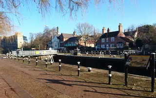 Empty canal lock with houses on the opposite bank and a mediaeval castle