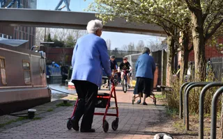 Elderly person walking on a canal towpath