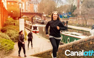 Woman running alongside the canal in Birmingham as part of Canalathon