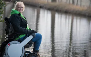 A woman sits in a wheelchair on the towpath