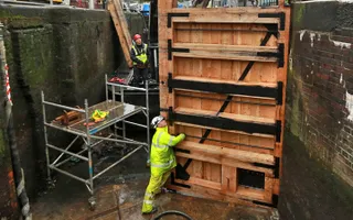 A workman fixing a new lock gate in a drained canal