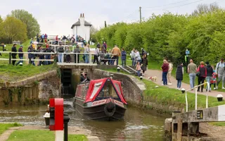 Boat descending down a lock flight with people watching