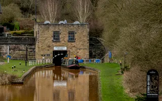Overcast day, narrowboat entering Harecastle Tunnel on famous copper waters in Kidsgrove