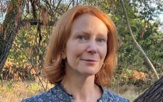 Woman head shot with trees in the background