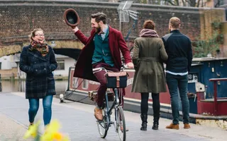 Cyclists doffs his hat to passing pedestrians on the canal towpath