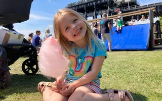 Girl holding candy floss and smiling at the camera