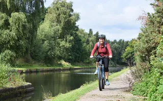 Woman cycling by the canal