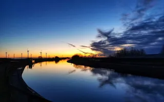Sunsetting over canal, blue and yellow skies