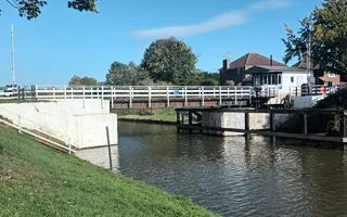 Wide shot of a canal with bridge in the background