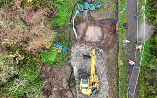Ariel shot of a canal and repair workers with digger