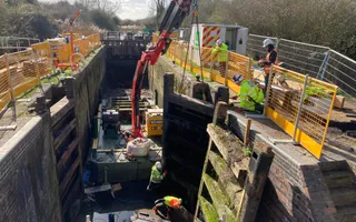 Wide shot of a crane lifting a lock gate out of a canal