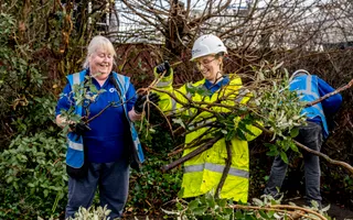 Two volunteers working to clear tree cuttings
