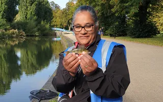 Let's Fish coach Suzie Galloway holds up a fish she's caught next to the canal