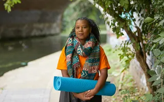 A woman with a yoga mat by the canal