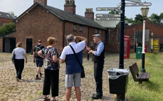 Visitors chatting outside the museum listening to tour guide